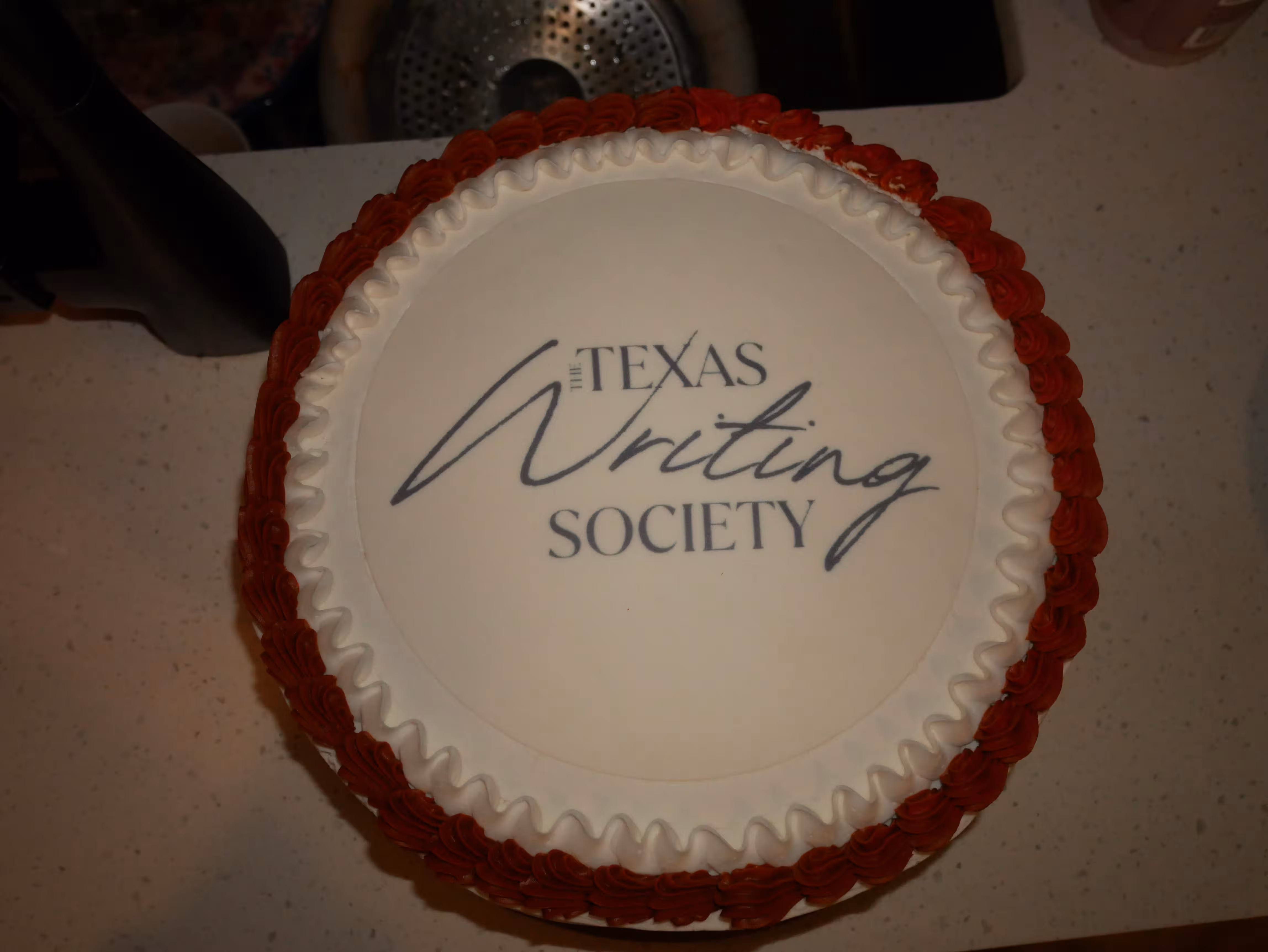 A celebration cake reading The Texas Writing Society